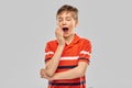 Portrait of tired yawning boy in red polo t-shirt