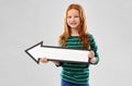 Smiling red haired girl with arrow showing to left Royalty Free Stock Photo