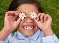 Childhood fun and bliss. a little girl covering her eyes with flowers while playing outside. Royalty Free Stock Photo