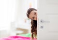 Happy smiling beautiful girl behind door at home Royalty Free Stock Photo