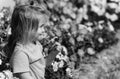 Childhood, happiness. Cute happy baby boy playing at flowerbed with blossoming flowers