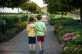 Childhood, hiking, family, friendship and people concept - two happy kids walking along forest path Royalty Free Stock Photo