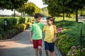 Childhood, hiking, family, friendship and people concept - two happy kids walking along forest path Royalty Free Stock Photo