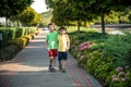 Childhood, hiking, family, friendship and people concept - two happy kids walking along forest path Royalty Free Stock Photo