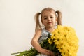Childhood, holidays, flowers, gifts concept - little cute three year old girl with two ponytails on her head in blue Royalty Free Stock Photo