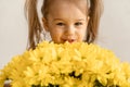 Childhood, holidays, flowers, gifts concept - little cute three year old girl with two ponytails on her head in blue Royalty Free Stock Photo