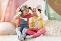 Girls with kitchenware playing in tent at home