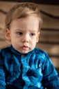 Childhood, infant, minor concepts - close up one blonde black-eyed sad, offended child baby boy on soft powdery bed in