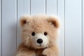 Childhood joy Cute teddy bear hides behind white wooden door Royalty Free Stock Photo