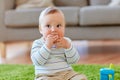 Baby boy on floor and eating rice cracker at home Royalty Free Stock Photo