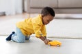 African american baby boy playing with toy car