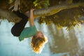 Childhood leisure, happy kids climbing up tree and having fun in summer park. Young boy playing and climbing a tree and