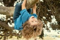 Childhood leisure. Happy kids hanging upside down on tree and having fun in summer park. Monkeying Around. Royalty Free Stock Photo