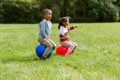 happy children bouncing on hopper balls at park