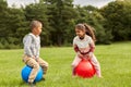 happy children bouncing on hopper balls at park Royalty Free Stock Photo