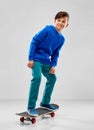 Smiling boy in blue hoodie with skateboard