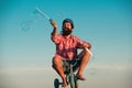 Childhood memory. Portrait of a bearded man as a crazy hipster having fun with bicycle outdoors.