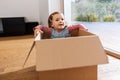 little baby girl sitting in cardboard box at home Royalty Free Stock Photo