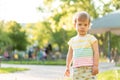 Childhood, nature, summer, parks and outdoors concept - portrait of cute blond-haired little boy in striped multi