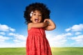 Childhood and people concept-cheerful african american little girl over landscape background