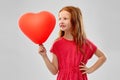 Smiling red haired girl with heart shaped balloon Royalty Free Stock Photo