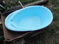 A childhood plastic bath is lying in an old cart