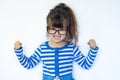 Childhood, power, gesture and people concept - happy smiling little girl with raised hand. Funny strong child with eye glasses Royalty Free Stock Photo