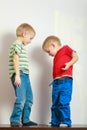 Two little boys siblings playing together on table