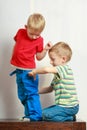 Two little boys siblings playing together on table