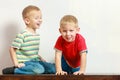 Two little boys siblings playing together on table
