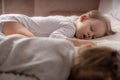 Childhood, sleep, relaxation, family, lifestyle concept - two young children 2 and 3 years old dressed in white and Royalty Free Stock Photo