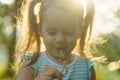 Childhood, summer and leisure concept.One cute happy little baby standing in bright grass with dandelions in backlight Royalty Free Stock Photo