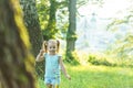 Childhood, summer and leisure concept.One cute happy little baby standing in bright grass with dandelions in backlight Royalty Free Stock Photo