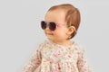 Happy little baby girl in sunglasses over grey Royalty Free Stock Photo