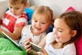 Little kids with smartphone in bed at home Royalty Free Stock Photo
