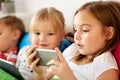 Little kids with smartphone in bed at home Royalty Free Stock Photo