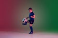 Teen male football or soccer player, boy on gradient background in neon light - motion, action, activity concept Royalty Free Stock Photo