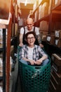 Childing warehouse workers playing with a cart, she is riding in it, he pushes Royalty Free Stock Photo