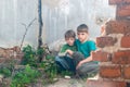 Children in an abandoned house, two poor abandoned boys, orphans as a result of natural disasters and military actions. Submission Royalty Free Stock Photo