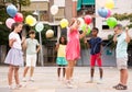 Happy tweenagers with balloons playing chinese jump rope in yard