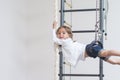 Children Activity Concepts. Little Caucasian Girl Having Exercises on Wall Bars Indoors. Royalty Free Stock Photo