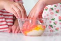 Children add food coloring to the salt in a glass bowl and mix it with their hands. Colored salt art. DIY Play and Learn