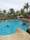 Children and adult tourists enjoying leisure activities having fun playing around resort water park Royalty Free Stock Photo