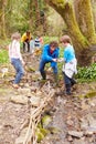 Children And Adults Carrying Out Conservation Work On Stream