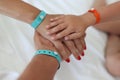 Children and adults` hands with bracelets are joined together. Royalty Free Stock Photo