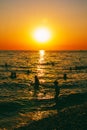 Children and adults swim in the sea in the evening Royalty Free Stock Photo