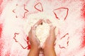 Children bake cookies for Christmas. Hands, star, tree, bell, heart, flour on a red background. Top view