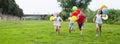 Children with balloons run in the summer park Royalty Free Stock Photo