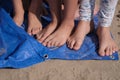 Children with bare feet are standing on a blue synthetic coating