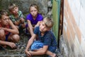 Children in the basement, three boys and a girl near the iron door are hiding on the steps from the outside world. Post-production Royalty Free Stock Photo